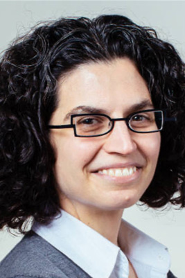 Woman smiling with curly hair and glasses